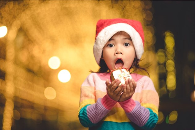 サンタクロースからのプレゼントに驚いている子ども